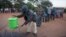 Des personnes font la queue pour se laver les mains afin de se protéger du coronavirus dans un bureau de vote, à Lilongwe, au Malawi, le 23 juin 2020. 
