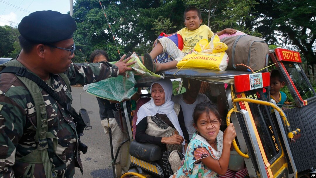 Warga yang melarikan diri dari kota Marawi yang terkepung ditanyai oleh tentara pemerintah di sebuah pos pemeriksaan, 26 Mei 2017.