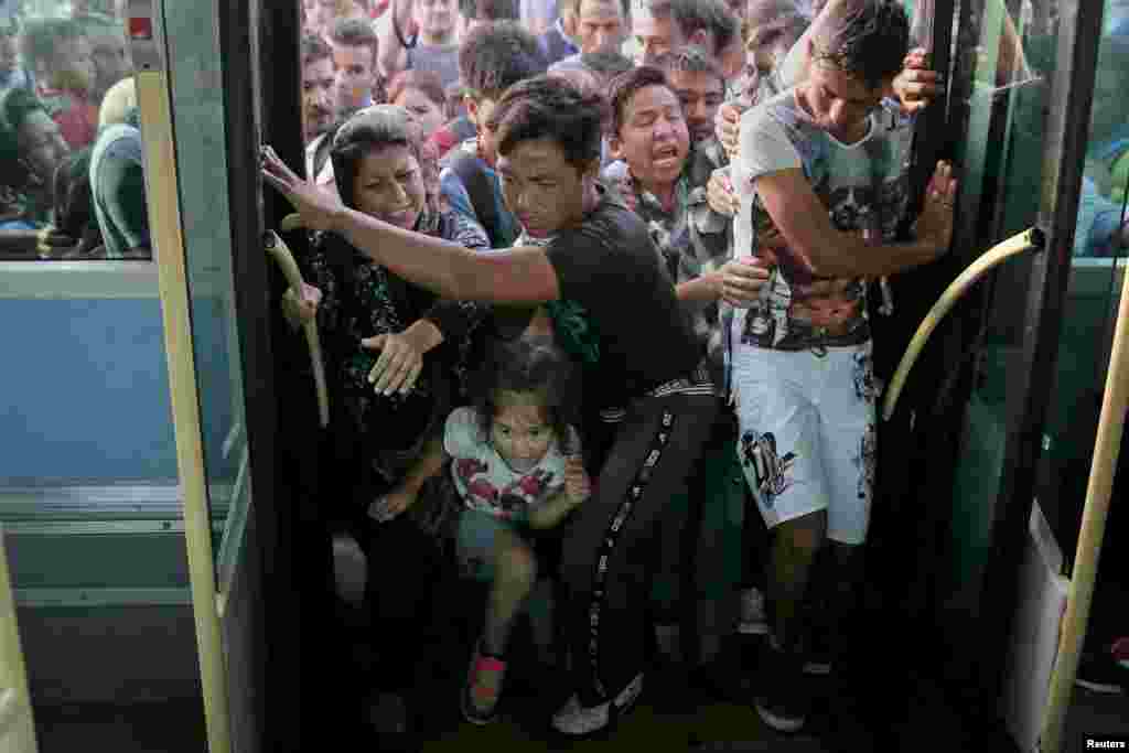 Refugees and migrants push each other as they try to board a bus following their arrival onboard the Eleftherios Venizelos passenger ship at the port of Piraeus, near Athens, Greece, Sept. 7, 2015.