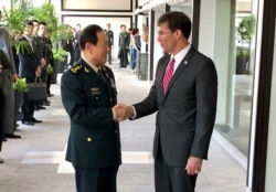 FILE - Chinese Defense Minister Wei Fenghe, left, greets U.S. Defense Secretary Mark Esper in Bangkok, Thailand, Nov. 18, 2019.