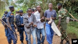 FILE - Three men walk in handcuffs after being arrested as organizers of an opposition demonstration, which was dispersed by police firing in the air, in Jenda, Burundi, June 12, 2015. 