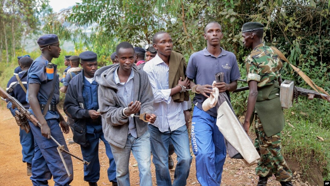 Tiga pria diborgol karena menjadi penyelenggara demo, yang dibubarkan oleh polisi di Jenda, Burundi, 12 Juni 2015. 