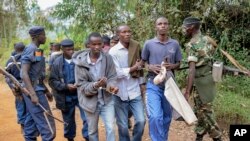 Tiga pria diborgol karena menjadi penyelenggara demo, yang dibubarkan oleh polisi di Jenda, Burundi, 12 Juni 2015. 