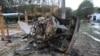 ARCHIVO - Un automóvil destruido por la explosión de un coche bomba cercano se encuentra en la carretera en Saravena, Arauca, Colombia, el jueves 20 de enero de 2022.