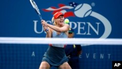 Maria Sharapova, of Russia, returns a shot to Alexandra Dulgheru, of Romania, during the second round of the U.S. Open tennis tournament Wednesday, Aug. 27, 2014, in New York. (AP Photo/Jason DeCrow)