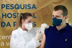 Nurse Isabelli Guasso administers China's Sinovac potential vaccine for the COVID-19 to volunteer Dr. Luciano Marini, at the Sao Lucas Hospital of the Pontifical Catholic University of Rio Grande do Sul in Porto Alegre, Brazil Aug. 8, 2020.