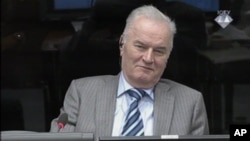 In this image taken from video former Bosnian Serb army commander Gen. Ratko Mladic smiles during his appearance at the Yugoslav war crimes tribunal, Jan. 28, 2014, in the Hague, Netherlands.