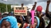 Un homme tient une pancarte indiquant «Une transition menée par l'armée» alors que des partisans du CNSP (Comité National pour le Salut du Peuple) participent à un rassemblement sur la place de l'Indépendance à Bamako, le 8 septembre 2020.