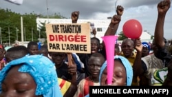 Un homme tient une pancarte indiquant «Une transition menée par l'armée» alors que des partisans du CNSP (Comité National pour le Salut du Peuple) participent à un rassemblement sur la place de l'Indépendance à Bamako, le 8 septembre 2020.