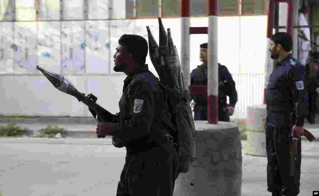 Afghan security personnel stand guard at the site of a deadly attack in Kabul. Officials say the political offices of the president&#39;s running mate were hit by a large explosion and stormed by an unknown number of attackers. Nasrat Rahimi, the interior ministry spokesman, said vice-presidential candidate and former intelligence chief Amrullah Saleh survived the attack.