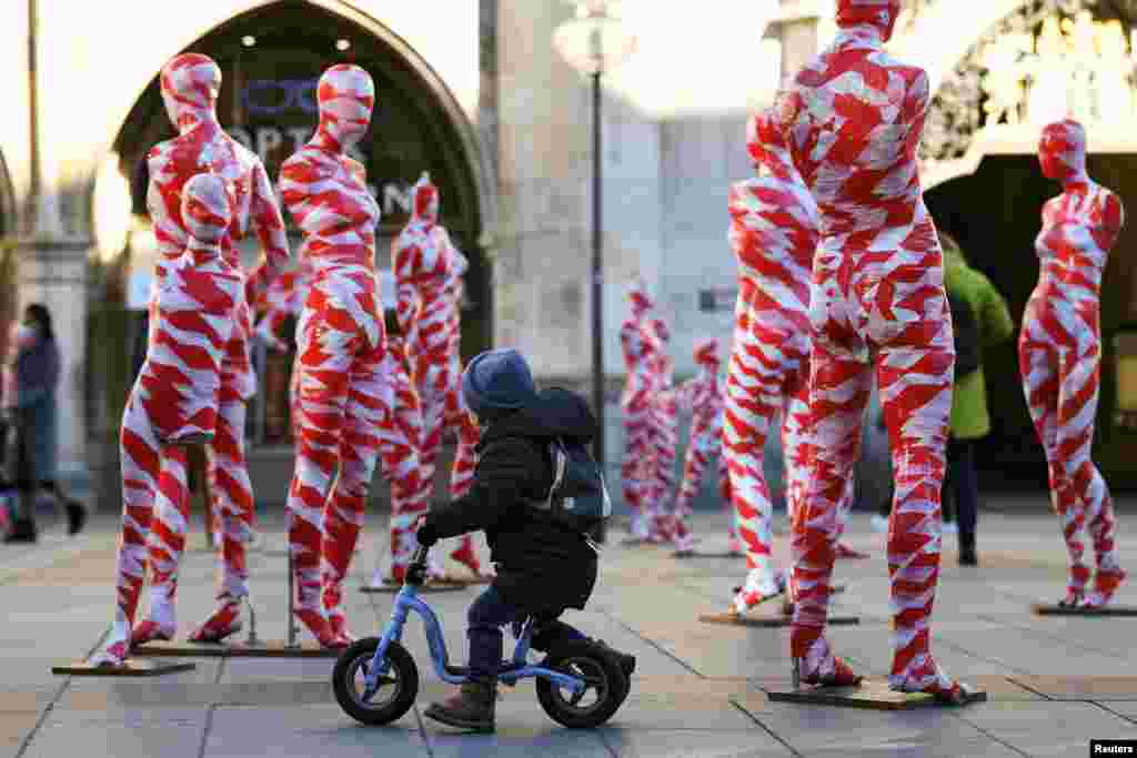 A little boy looks at an art installation featuring 111 mannequins, which is calling for more "mindfulness and appreciation" in times of the pandemic in Munich, Germany.