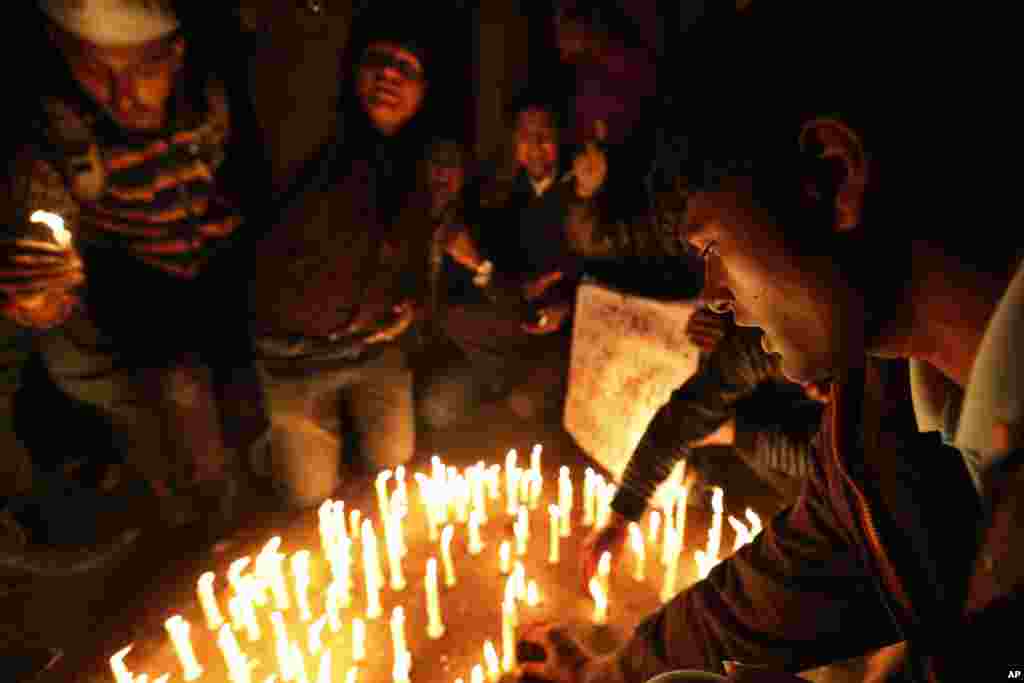 Warga berpartisipasi dalam doa bersama untuk kepulihan perempuan muda korban pemerkosaan dan penyiksaan di New Delhi (21/12). (AP/Saurabh Das)