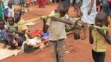 FILE - Boys play with toy guns made from long grass reeds at a displaced persons camp protected by U.N. peacekeepers in Wau, South Sudan, Sept. 4, 2016.