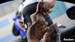 La gente cambia dólares estadounidenses por pesos colombianos en una calle de San Cristóbal, Venezuela, el 7 de abril de 2022.