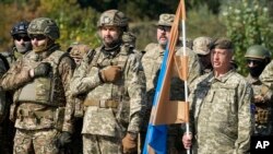 FILE - Reservists from the Ukrainian Territorial Defense Forces sing the national anthem at a military training ground outside Ukraine's capital, Kyiv, Oct. 2, 2021. Reservists are now a serious fighting force in Ukraine's war against Russian aggression. 