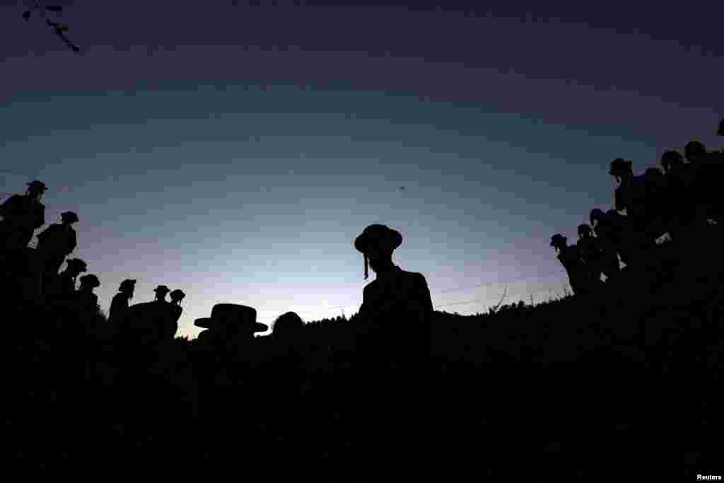 The silhouettes of ultra-Orthodox Jews are seen at dusk as they take part in a ceremony in preparation for Passover near Jerusalem in the Israeli-occupied West Bank.