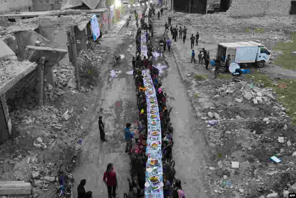 Syrians break their fast during an iftar gathering organised in Tadef, near the border city of al-Bab, which is controlled by Turkish-backed rebels in Syria&#39;s eastern countryside of Aleppo province, April 18, 2022.