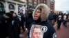 FILE: A woman wears a sweater with an image of Patrick Lyoya as protesters march for Lyoya, a Black man who was fatally shot by a police officer, in downtown Grand Rapids, Michigan, April 16, 2022.