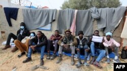 Des migrants africains manifestent contre le Haut Commissariat de l'ONU pour les réfugiés (HCR) en Tunisie près de la frontière libyenne, le 14 février 2022; exigeant leur réinstallation et leur evacuation vers d'autres pays, (AFP/ FATHI NASRI)