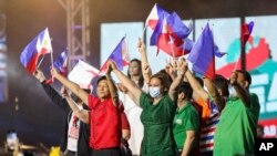 Mantan senator Ferdinand "Bongbong" Marcos Jr., kiri tengah, dan pasangannya Walikota Davao City Sara Duterte, kanan tengah, mengibarkan bendera Filipina saat pengumuman mengenai pencalonannya sebagai presiden. (Foto: AP)