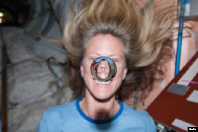 In this file photo, NASA astronaut Karen Nyberg watches a water bubble float freely between her and the camera, showing her image refracted in the droplet. (Image Credit: NASA)