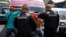 Policías registran a dos hombres en un autobús después de que el Congreso de El Salvador aprobara el martes un proyecto de ley que criminaliza la publicación de mensajes de las pandillas, incluso en medios de comunicación, en San Salvador, El Salvador, el 7 de abril de 2022.