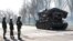 Service members of pro-Russian troops stand next to a combat engineering vehicle, in the southern port of Mariupol, Ukraine, April 20, 2022.