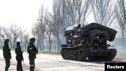 Anggota tentara pro-Rusia berdiri di dekat tank di Mariupol selatan, Ukraina, 20 April 2022.