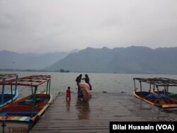 Visitors posing on bank of Nigeen Lake in Srinagar.