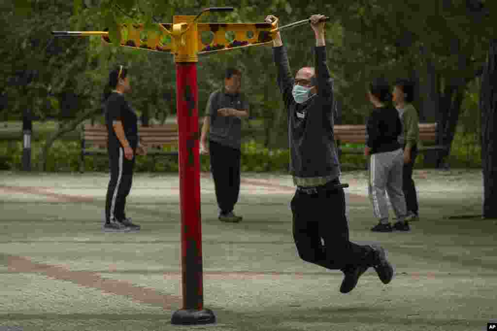 A man wearing a face mask exercises at a public park in Beijing, China.