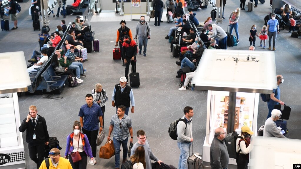 2022年4月19日，在联邦法官宣布对公共交通系统的口罩要求不再有效的一天后，美国科罗拉多州丹佛机场航站楼内一些准备搭机的乘客，已经不再佩戴口罩。(photo:VOA)