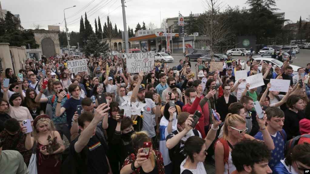  FILE - Young protesters use the light from their phones during an anti-war demonstration in memory of the victims of fighting in Ukraine, in front of Ukrainian Embassy in Tbilisi, Georgia, April 3, 2022.
