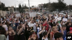Los jóvenes arrojaron la luz de sus teléfonos celulares durante una acción contra la guerra en memoria de las víctimas de los combates en Ucrania frente a la Embajada de Ucrania en Tbilisi, Georgia, el 3 de abril de 2022.