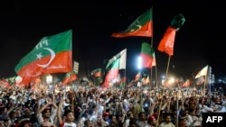 Supporters of ousted Pakistan's prime minister Imarn Khan of Pakistan Tehreek-e-Insaf (PTI) party, hold flags and signs as they gather during a public rally in Peshawar on April 13, 2022.