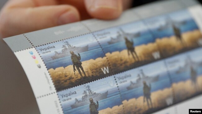 Ukrainian postal service chief Igor Smelyansky holds postage stamps showing a Ukrainian service member's gesture toward a Russian warship at postal service headquarters in Kyiv, April 14, 2022.