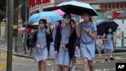 香港小学生戴着口罩去学校上学接受面对面教学。（2022年4月19日）