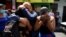 Mujeres reaccionan al reconocer a sus familiares detenidos que están siendo trasladados a una prisión después de que el Congreso de El Salvador aprobara reformas penales tras 89 asesinatos denunciados, durante el fin de semana en San Salvador, El Salvador, el 1 de abril de 2022