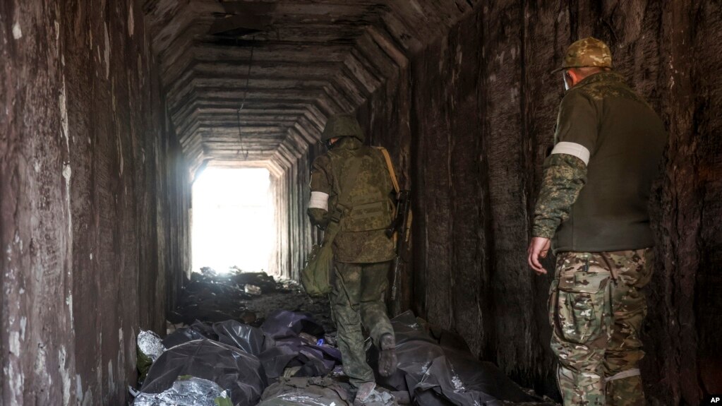 Servicemen of the Donetsk People's Republic militia look at bodies of Ukrainian soldiers placed in plastic bags in a tunnel. (AP Photo/Alexei Alexandrov, File)