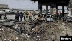 Ukrainian servicemen and rescuers inspect the site of military strikes on buildings as Russia's attack on Ukraine continues, in Lviv, Ukraine, April 18, 2022. 