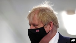 FILE - Britain's Prime Minister Boris Johnson wears a face mask during a visit to Milton Keynes University Hospital in Buckinghamshire, England, Jan. 24, 2022. 