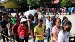 Residents line up to vote during the second round of the presidential election in Dili, East Timor, April 19, 2022.