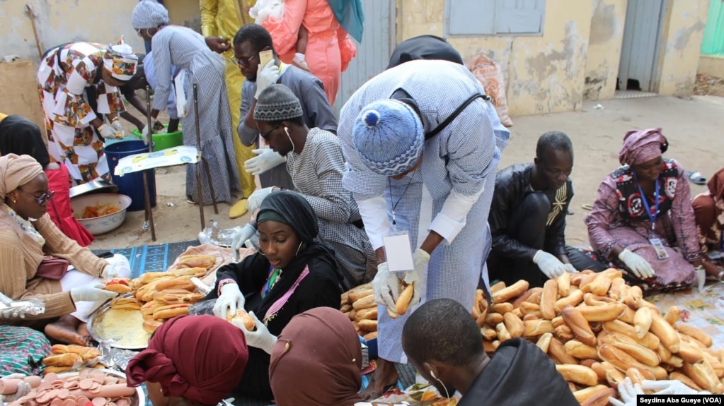 Des jeunes distribuent le Ndogou à Dakar. (VOA/Seydina Aba Gueye)<br />
