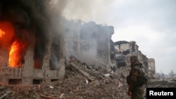 Un combatiente de las fuerzas prorrusas se encuentra frente al edificio administrativo destruido de Azovstal Iron and Steel Works durante el conflicto Ucrania-Rusia en la ciudad de Mariúpol, Ucrania, 21 de abril de 2022.