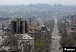 FILE - FILE PHOTO: A view shows damaged buildings, with the Azovstal Iron and Steel Works plant in the background, in the southern port city of Mariupol, Apr. 19, 2022.