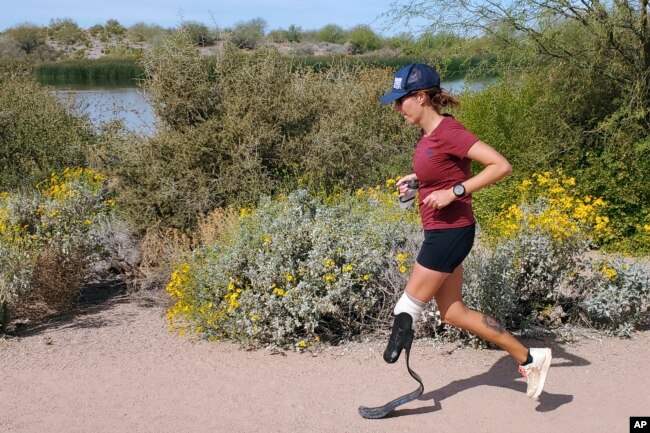 In this image provided by Edwin Broersma, marathoner Jacky Hunt-Broersma runs her 80th consecutive marathon on March 27, 2022, near her home in Gilbert, Az. (Edwin Broersma via AP)