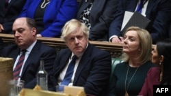 A handout photograph released by the UK Parliament shows Britain's Defense Secretary Ben Wallace (L), Prime Minister Boris Johnson (C) and Foreign Secretary Liz Truss (2nd R) attending a session in the House of Commons, in London, Feb. 24, 2022.
