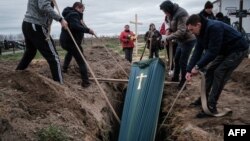 Relatives of Mykhailo Romaniuk, 58, who was shot dead on his bicycle on March 6, help to bury his coffin at a cemetery in Bucha, on April 19, 2022, during the Russian invasion of Ukraine.