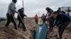 Relatives of Mykhailo Romaniuk, 58, who was shot dead on his bicycle on March 6, help to bury his coffin at a cemetery in Bucha, on April 19, 2022, during the Russian invasion of Ukraine.