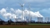 FILE - Renewable and fossil-fuel energy is produced when wind generators are seen in front of a coal-fired power plant near Jackerath, Germany, Dec. 7, 2018. 
