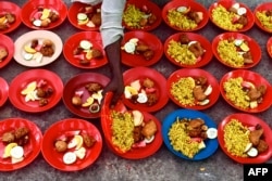 Seorang sukarelawan menyiapkan makanan buka puasa menjelang saat berbuka pada bulan suci Ramadan, di sebuah kuil di Dhaka, BAngladesh, 12 April 2022. (Foto: Munir uz ZAMAN / AFP)